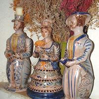 Tre lumere siciliane riccamente decorate posizionate sul camino di un antico casale